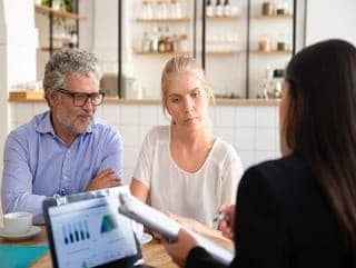 financial-insurance-agent-meeting-with-young-mature-customers-co-working-showing-agreement-explaining-details (1)
